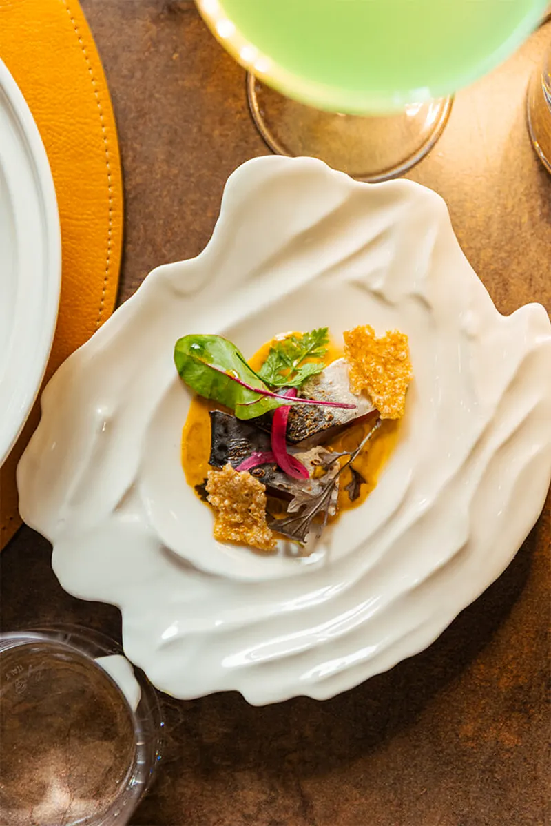 Un antipasto di pesce in un piatto bianco a forma di conchiglia, da Masa Roof Top