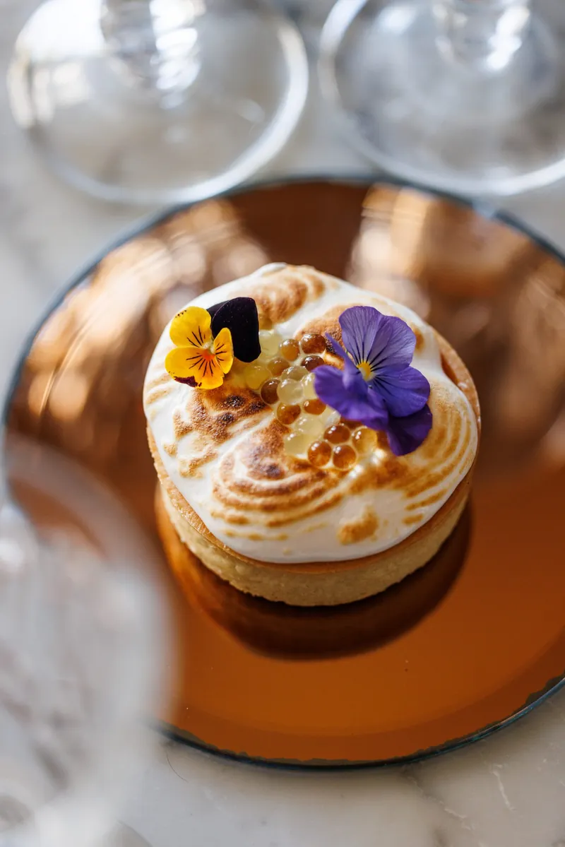 Un dessert di Notramè con meringa fiammata e viole